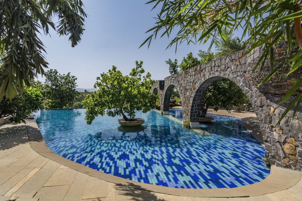 Split level shared infinity pool villa adorned with Greek-style rock pillars