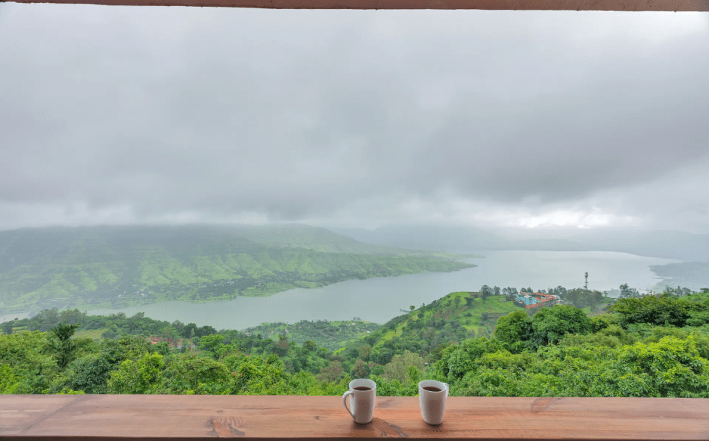 Table Land plateau in Panchgani, cloud drifting across the flat expanse at eye level, green grass covering what would be cracked brown earth in summer.