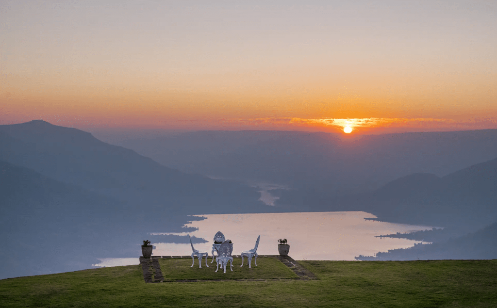 SaffronStays Gold Mist in Mahabaleshwar during monsoon, mist rolling through the valley below, boats on the lake if using the Venna Lake option.