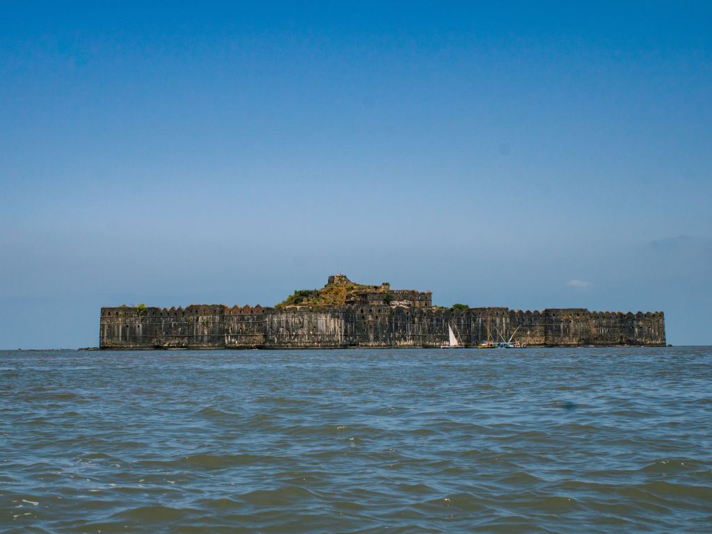 A large coastal fort surrounded by water under a clear blue sky.